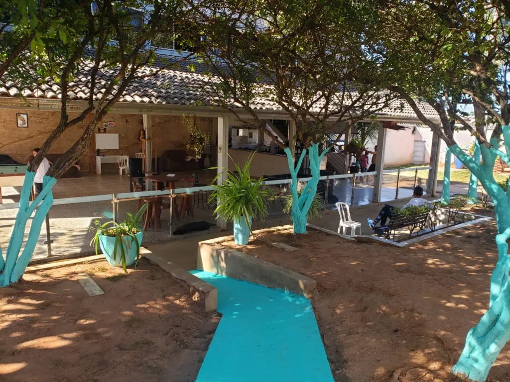 Área externa arborizada e a sede da Residência Terapêutica Luz do Sol, clínica de recuperação em Aparecida de Goiânia