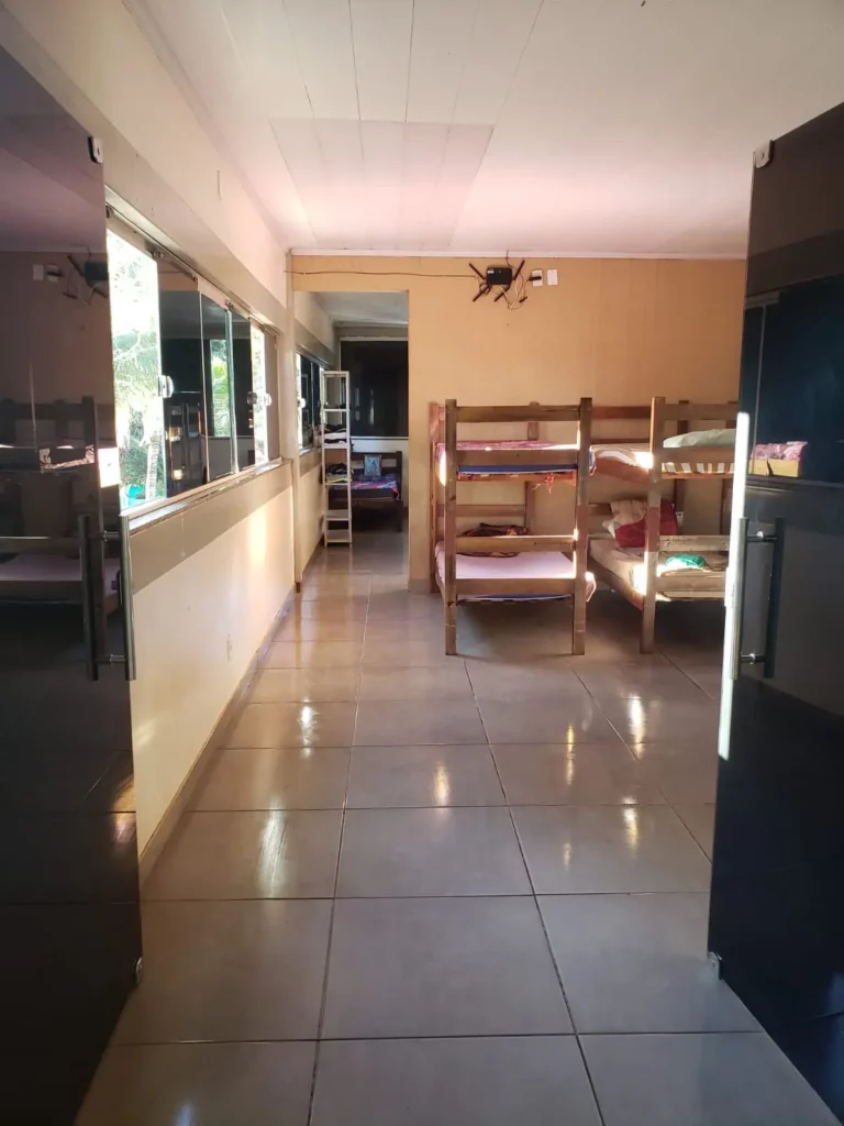 Alojamento com beliches e corredor amplo na Residência Terapêutica Luz do Sol em Aparecida de Goiânia